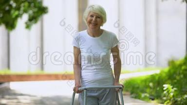 年轻的老年妇女，带着步<strong>行架</strong>，在户外看相机，康复